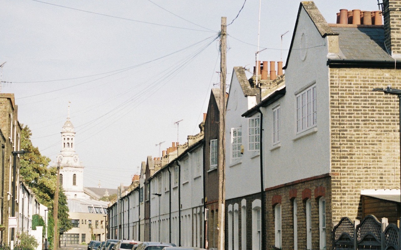 A residential street in Greenwich, London, with terraced houses and parked cars